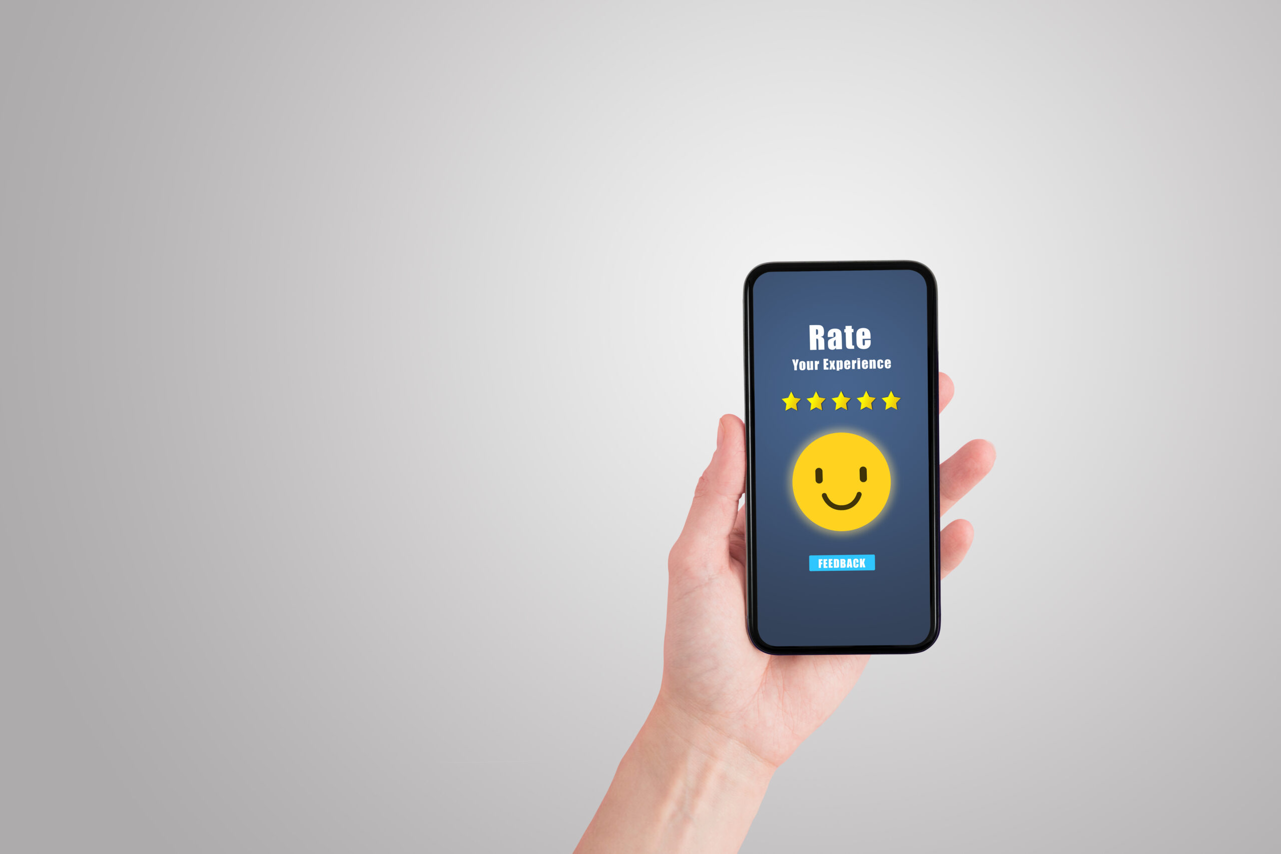 Customer Feedback Concept : Hand holding smartphone that showing five yellow stars and smiley icons symbol for giving best service ranking in business concept.